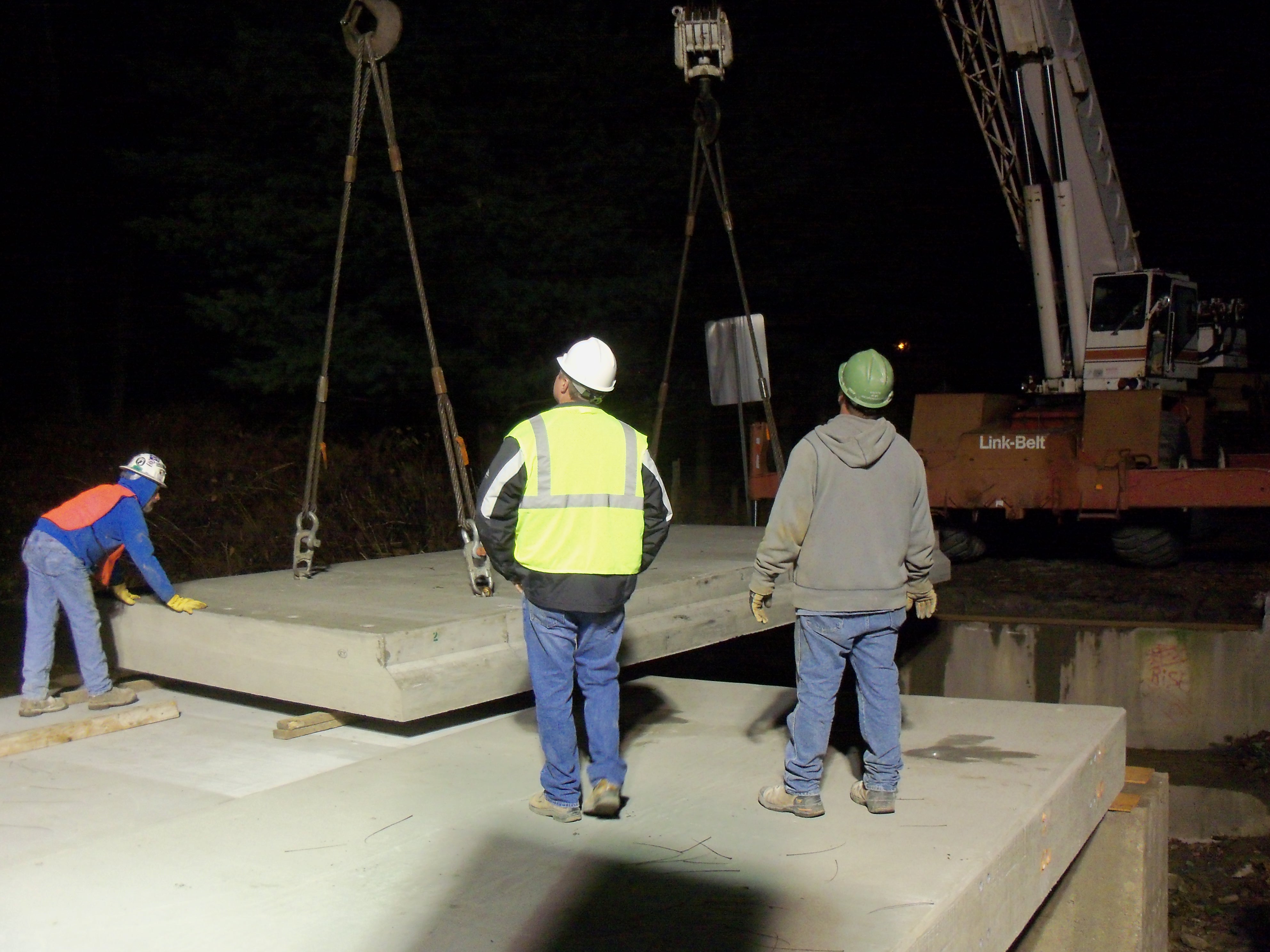 Workers installing one of the precast deck slabs