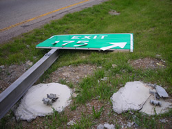 green damaged sign interstate exit sign laying on ground