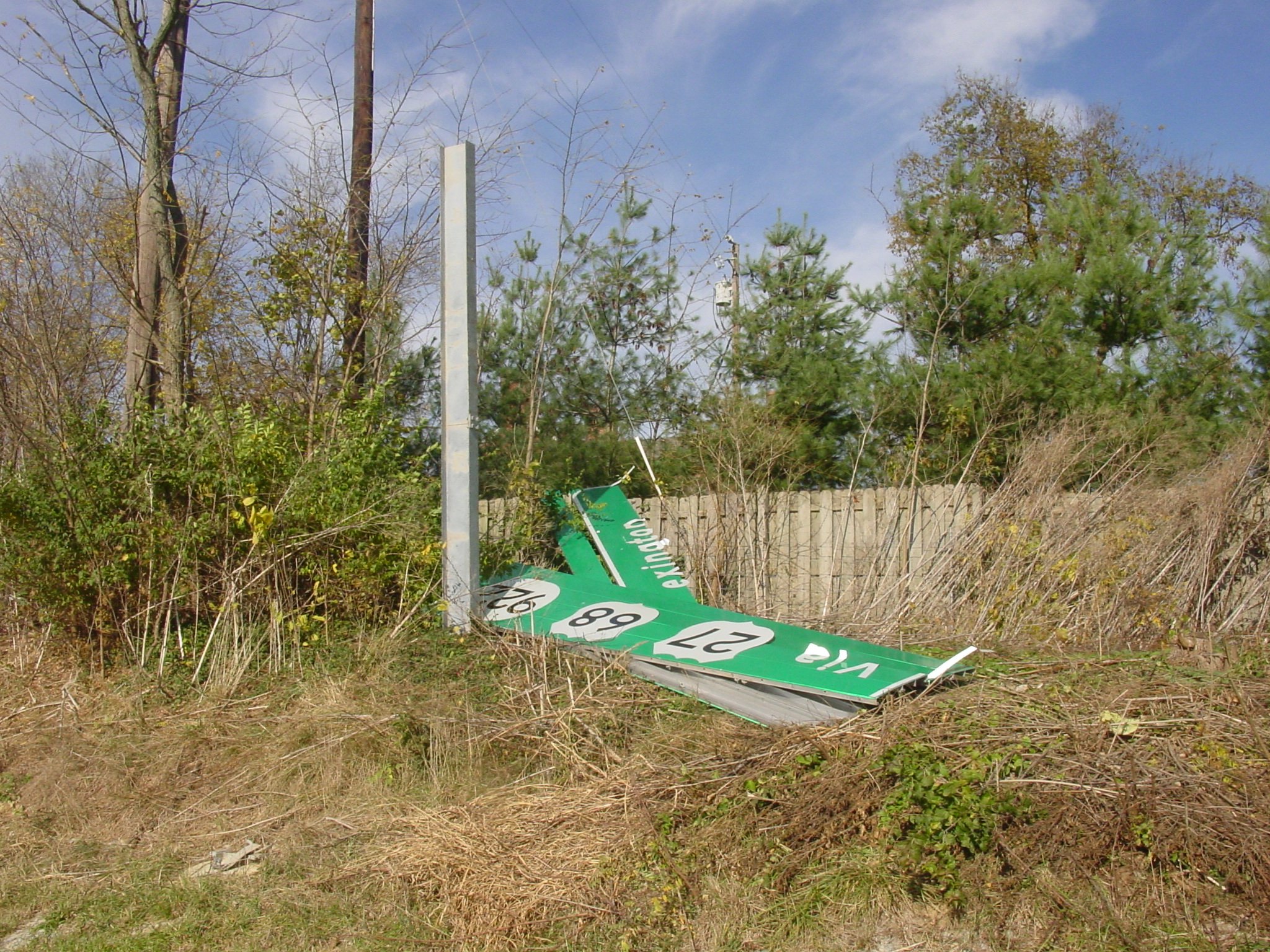 damaged green interstate sign laying on ground damaged